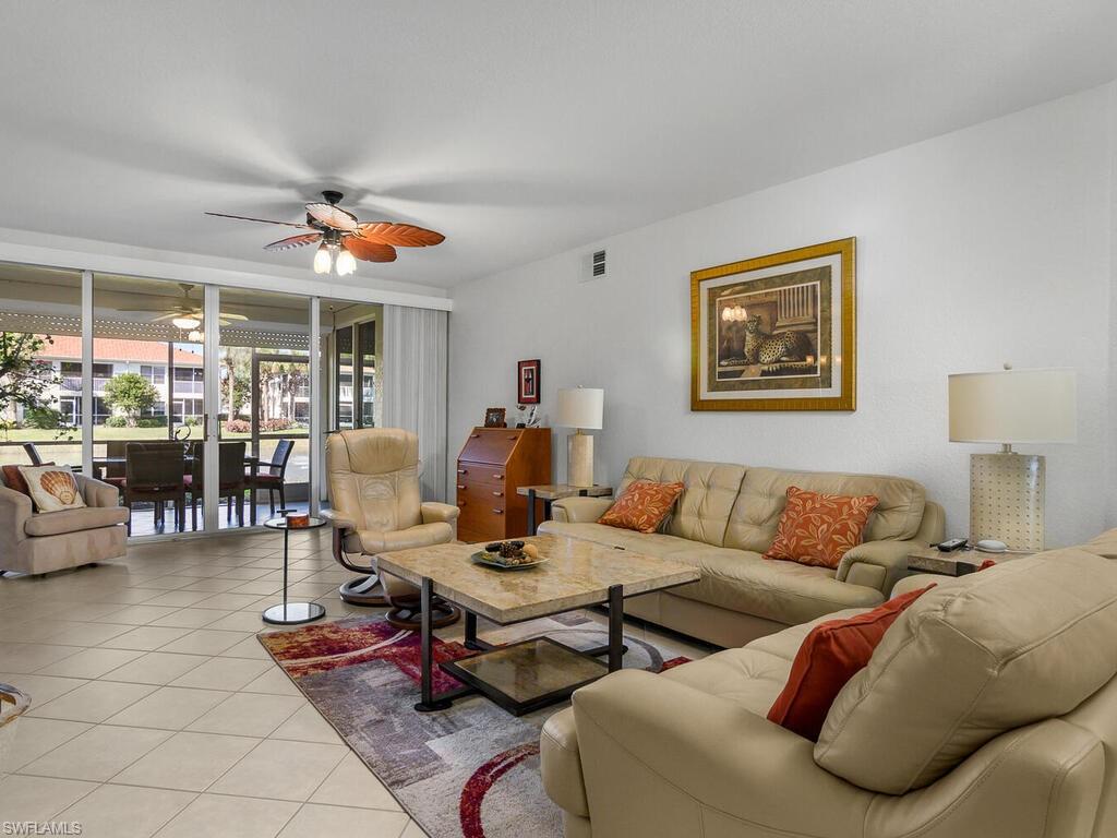 23831 San Marino Road, Unit 102 Estero, FL 34135 - Photo 8 of 39 Tiled living area featuring a ceiling fan and floor to ceiling windows