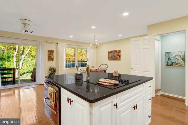 a kitchen with a stove a sink a refrigerator and wooden floor