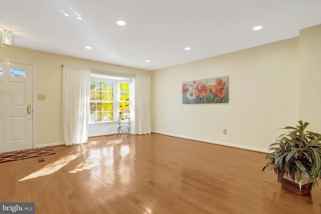 a view of an empty room with wooden floor and stairs