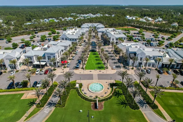an aerial view of residential houses with outdoor space and trees