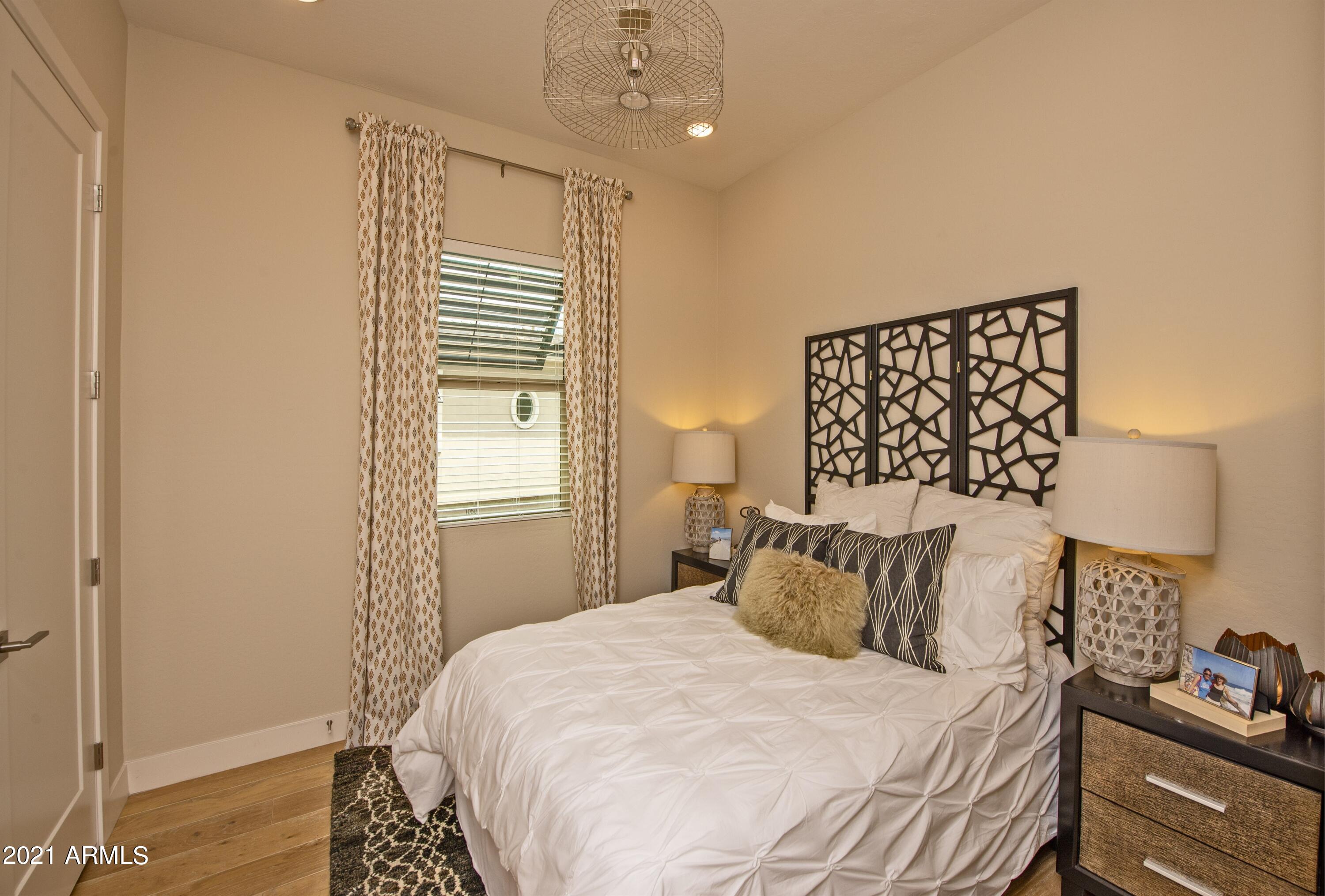 6565 East Thomas Road, Unit 1042 Scottsdale, AZ 85251 - Photo 12 of 22 a bedroom with a bed and wooden floor