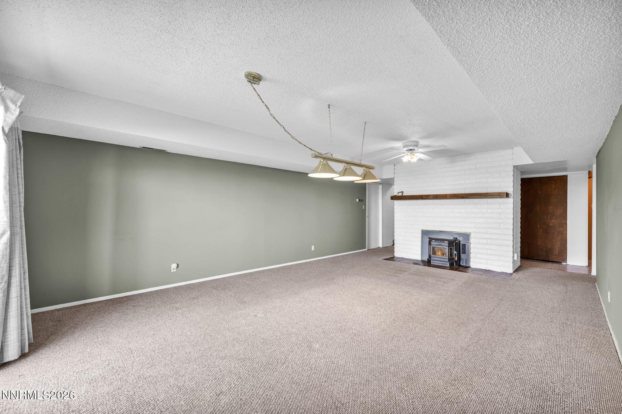 1970 Geiger Grade Road Reno, NV 89521 - Photo 30 of 45 an empty room with a fireplace and fan