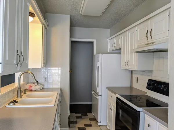 a kitchen with a sink stove and refrigerator