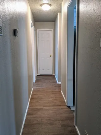 a view of a hallway with wooden floor