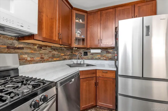 a kitchen with stainless steel appliances granite countertop a refrigerator stove and sink