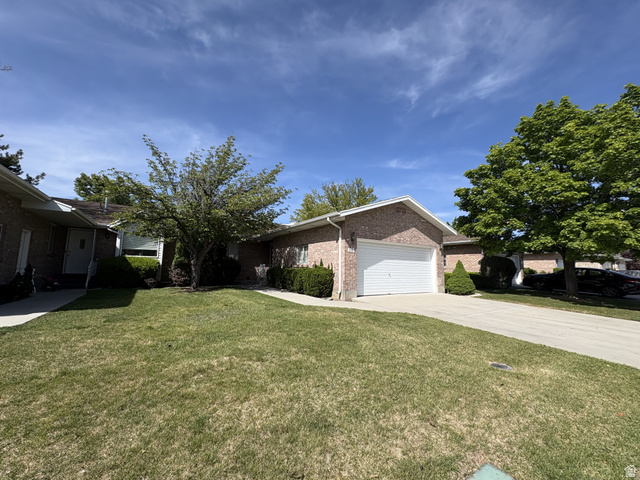 486 West 120 North Orem, UT 84057 - Photo 2 of 30 Brick exterior with an attached garage, concrete driveway, and mature landscaping