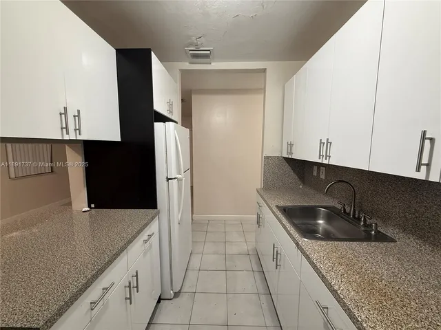 a kitchen with granite countertop a sink and a stove top oven