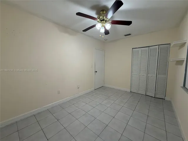 an empty room with chandelier fan