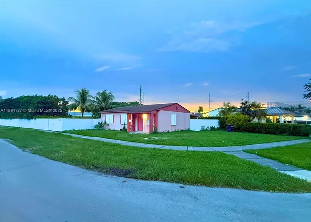 a view of a house with a big yard plants and large trees