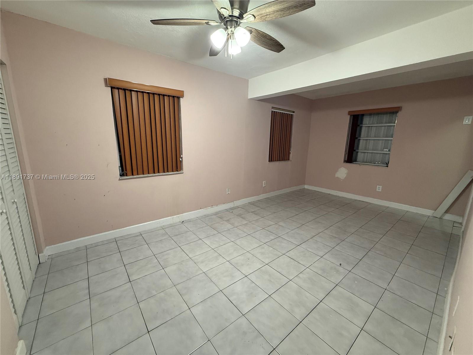 3450 Southwest 75th Court Miami, FL 33155 - Photo 8 of 22 an empty room with chandelier fan and windows