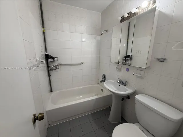 a white toilet sitting next to a bath tub
