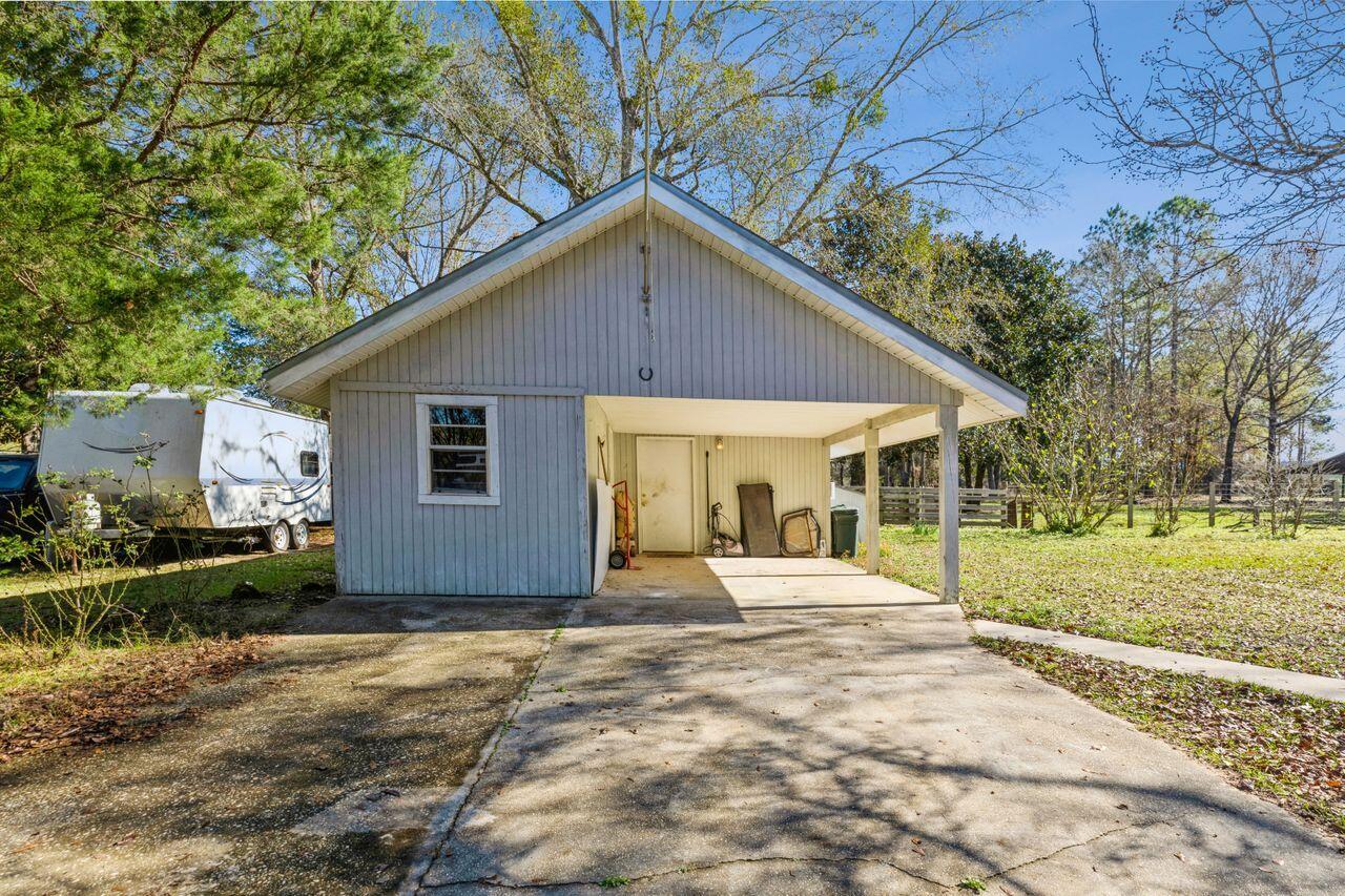 6391 Lumber Ridge Road Crestview, FL 32539 - Photo 28 of 48 a front view of a house with a yard and seating space