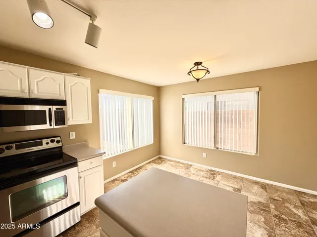 a kitchen with stainless steel appliances granite countertop a stove a sink and a microwave
