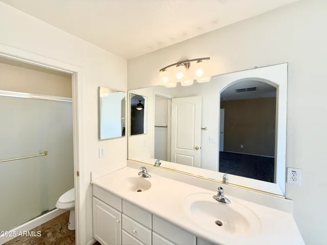 a bathroom with a sink a toilet and a mirror