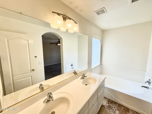 a bathroom with a tub sink and mirror