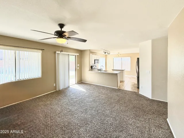 a view of a livingroom with a chandelier fan and windows