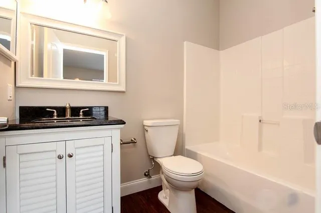 a bathroom with a toilet a sink and mirror