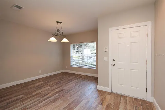 a view of a room with wooden floor and a ceiling fan