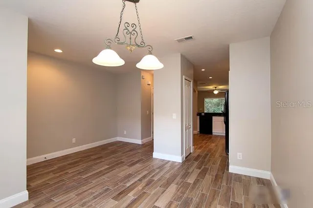 a view of a room with wooden floor and a ceiling fan