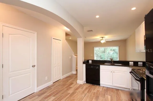 a kitchen with granite countertop a sink cabinets and wooden floor
