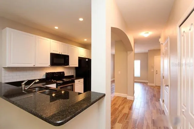 a kitchen with sink a refrigerator and microwave