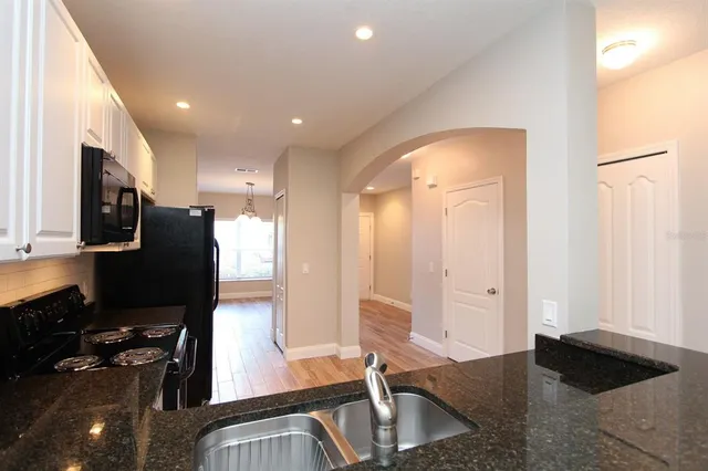 a kitchen with sink a refrigerator and microwave