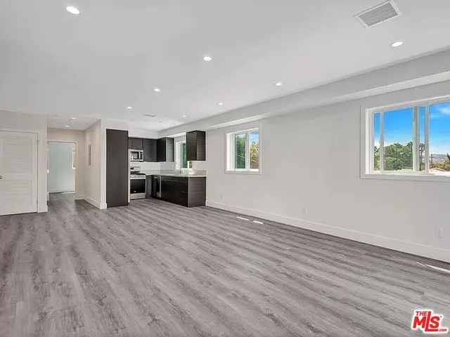 a view of a livingroom with a furniture wooden floor and windows
