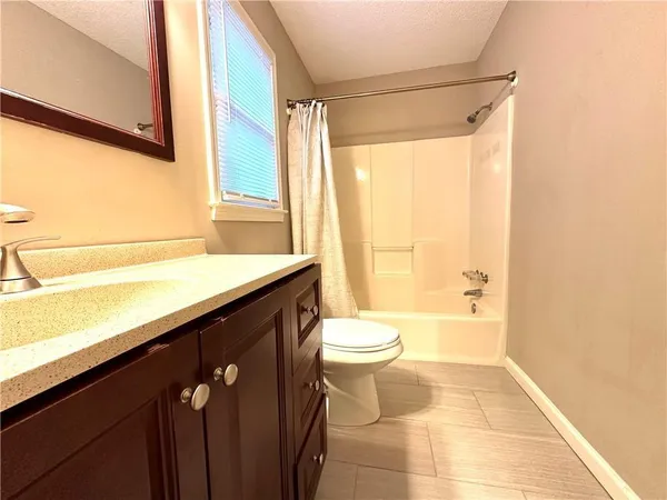 a bathroom with a granite countertop sink toilet and shower