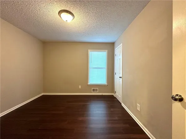 a view of room with window and wooden floor