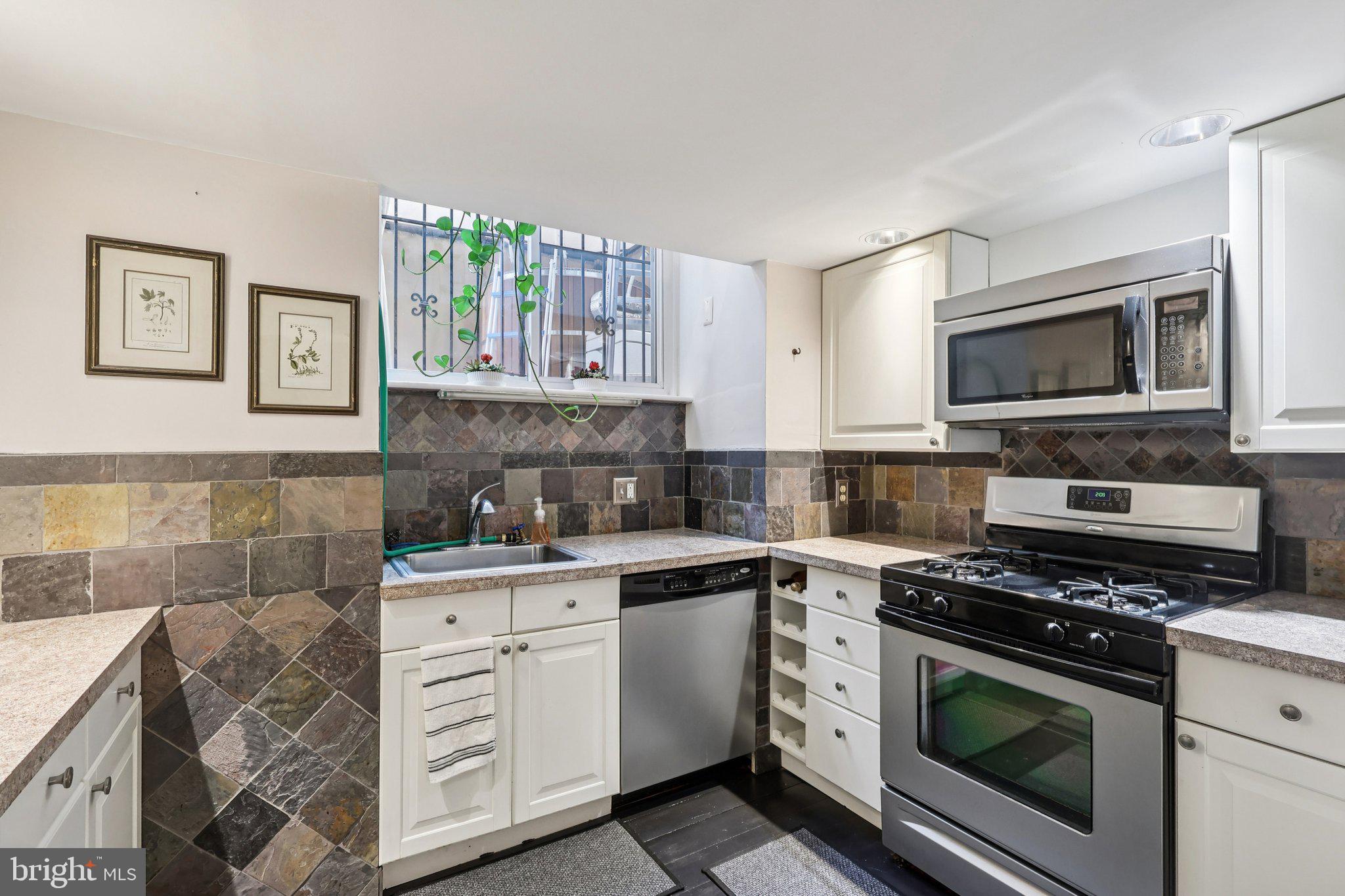 523 South Leithgow Street Philadelphia, PA 19147 - Photo 16 of 35 a kitchen with cabinets stainless steel appliances and a wooden floor
