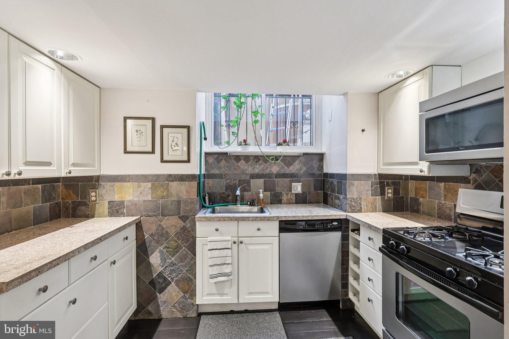523 South Leithgow Street Philadelphia, PA 19147 - Photo 17 of 35 a kitchen with granite countertop a stove top oven sink and cabinets