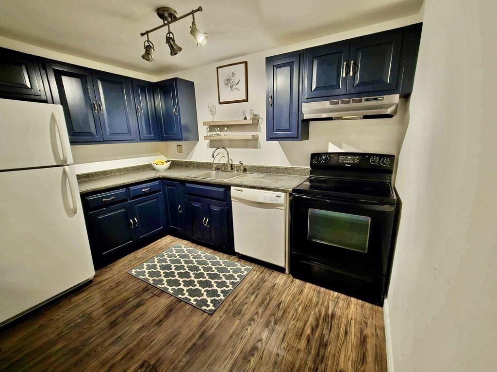 35 Berlin Street, Unit 218 Clinton, MA 01510 - Photo 5 of 13 a kitchen with stainless steel appliances granite countertop a stove a sink and a refrigerator