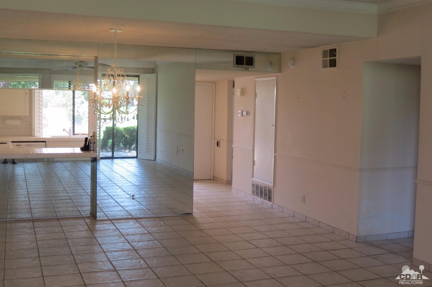 59 La Ronda Drive Rancho Mirage, CA 92270 - Photo 17 of 27 a view of a hallway with wooden floor and chandelier