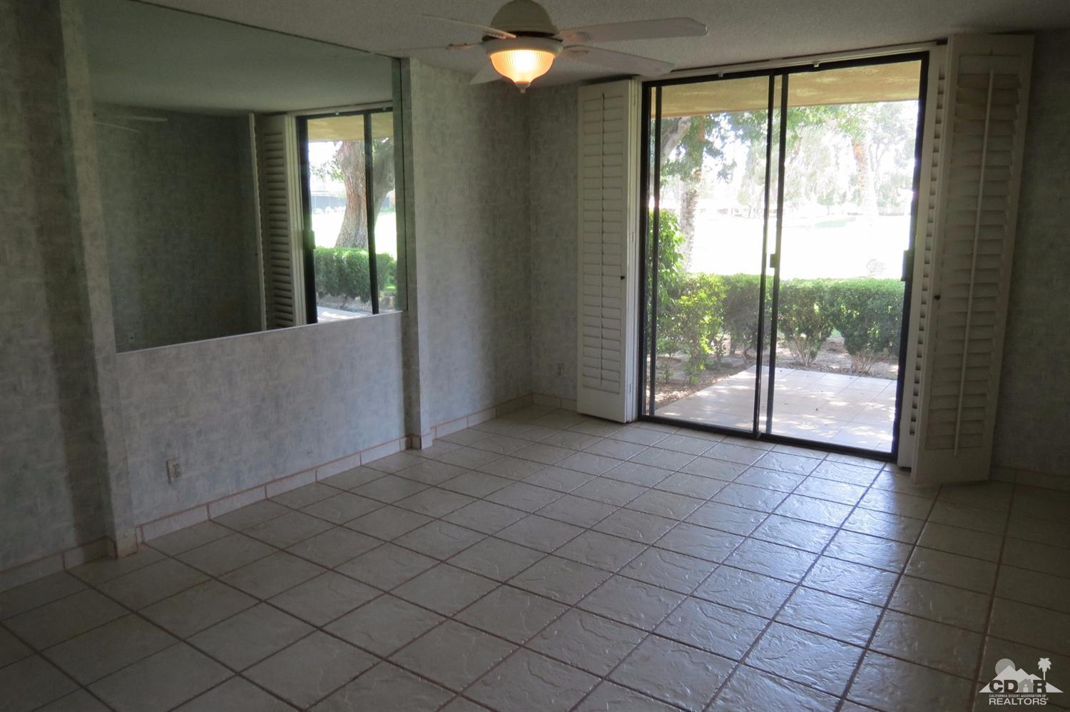 59 La Ronda Drive Rancho Mirage, CA 92270 - Photo 18 of 27 an empty room with floor to ceiling windows and table