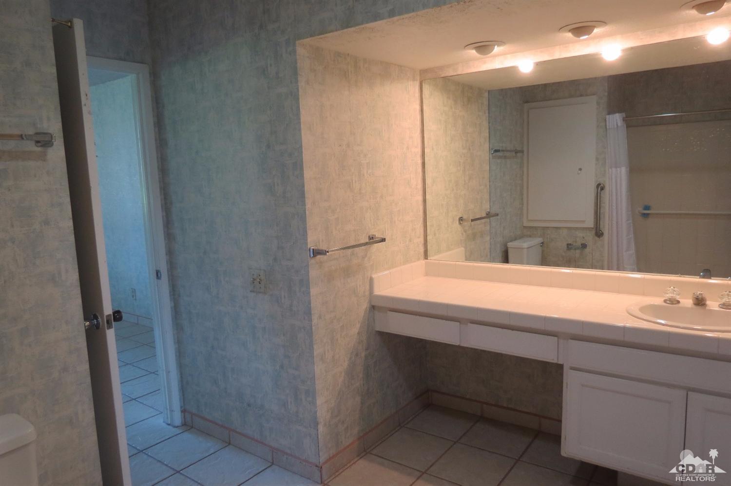 59 La Ronda Drive Rancho Mirage, CA 92270 - Photo 22 of 27 a bathroom with a sink and a mirror
