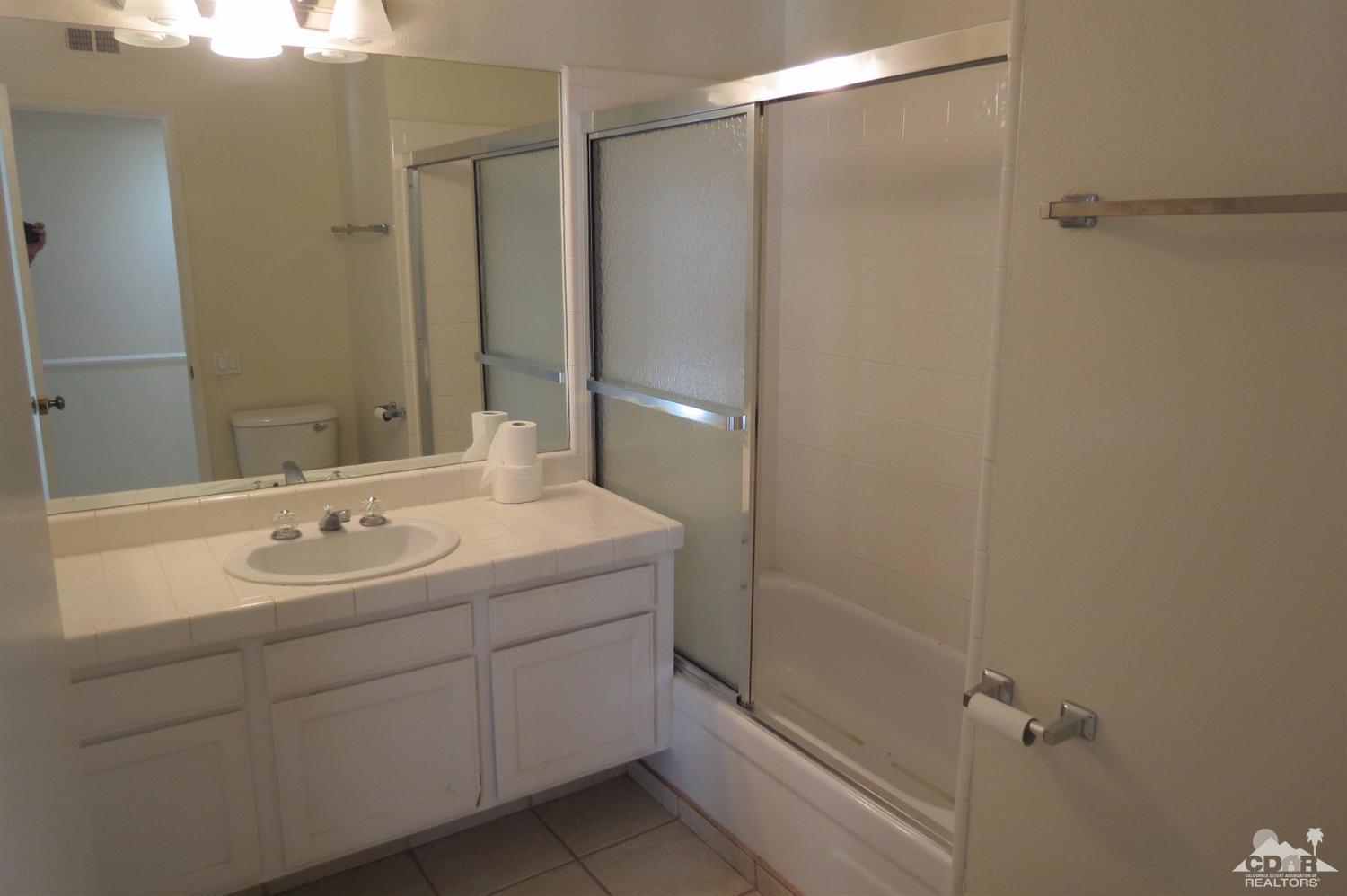 59 La Ronda Drive Rancho Mirage, CA 92270 - Photo 25 of 27 a bathroom with a sink and mirror