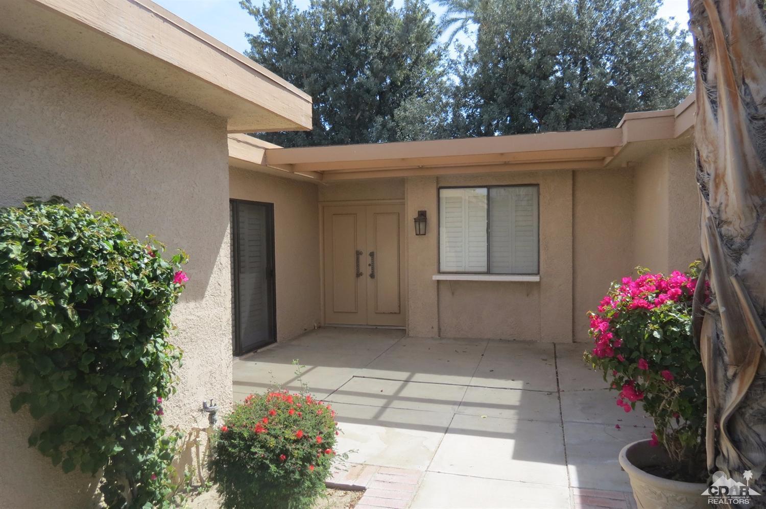 59 La Ronda Drive Rancho Mirage, CA 92270 - Photo 3 of 27 a house with flowers in front of it