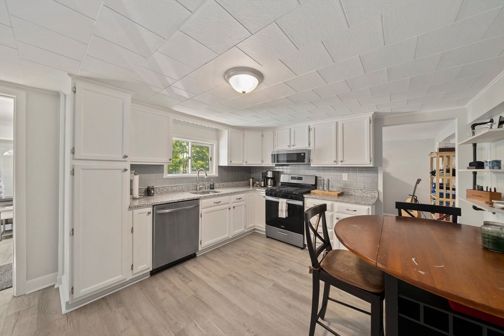 86 High Street Randolph, MA 02368 - Photo 4 of 28 a kitchen with a table chairs microwave and cabinets