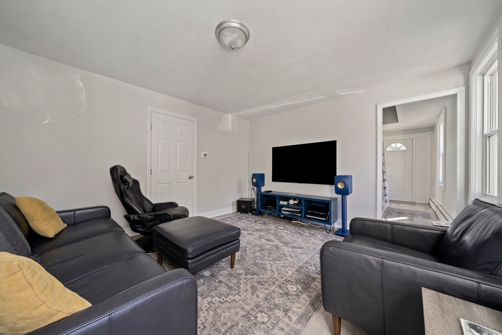 86 High Street Randolph, MA 02368 - Photo 7 of 28 a living room with furniture and a flat screen tv
