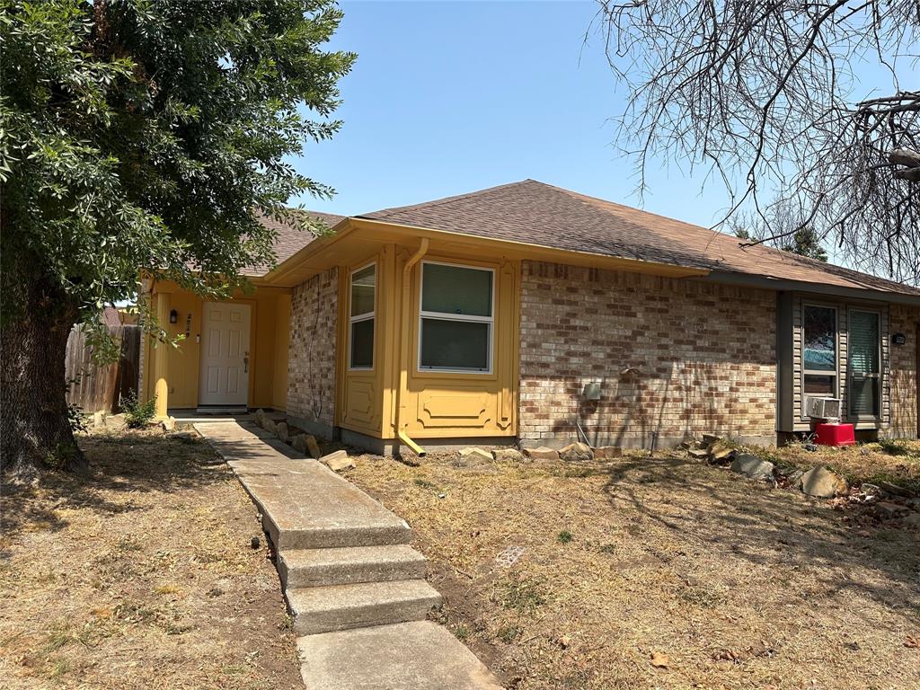 View of front of property with roof with shingles and brick siding