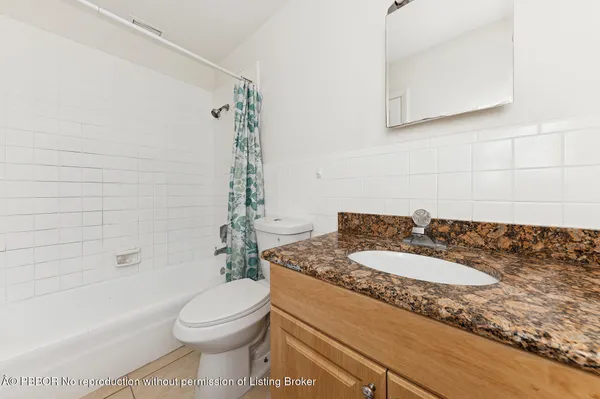 a bathroom with a granite countertop toilet sink and mirror