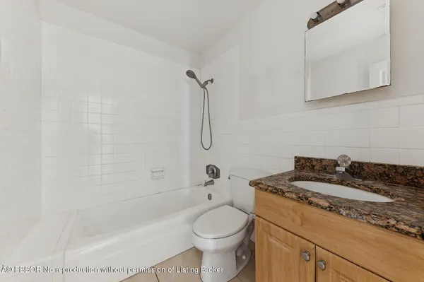 a bathroom with a granite countertop toilet a sink and bathtub