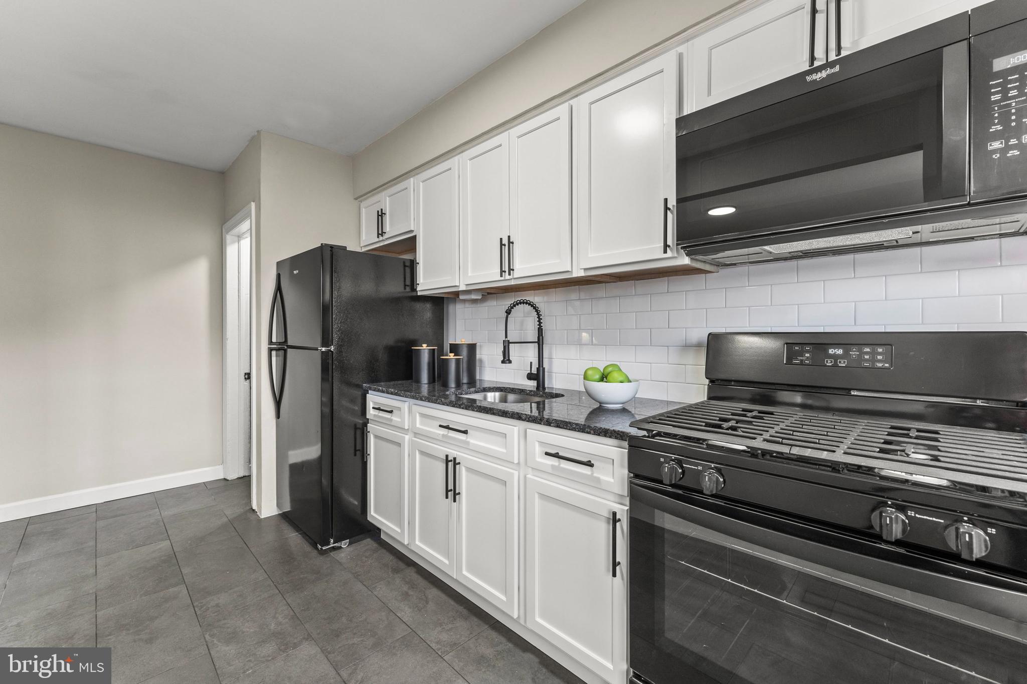 1324 Crofton Road Baltimore, MD 21239 - Photo 11 of 24 a kitchen with stainless steel appliances granite countertop a refrigerator stove and white cabinets