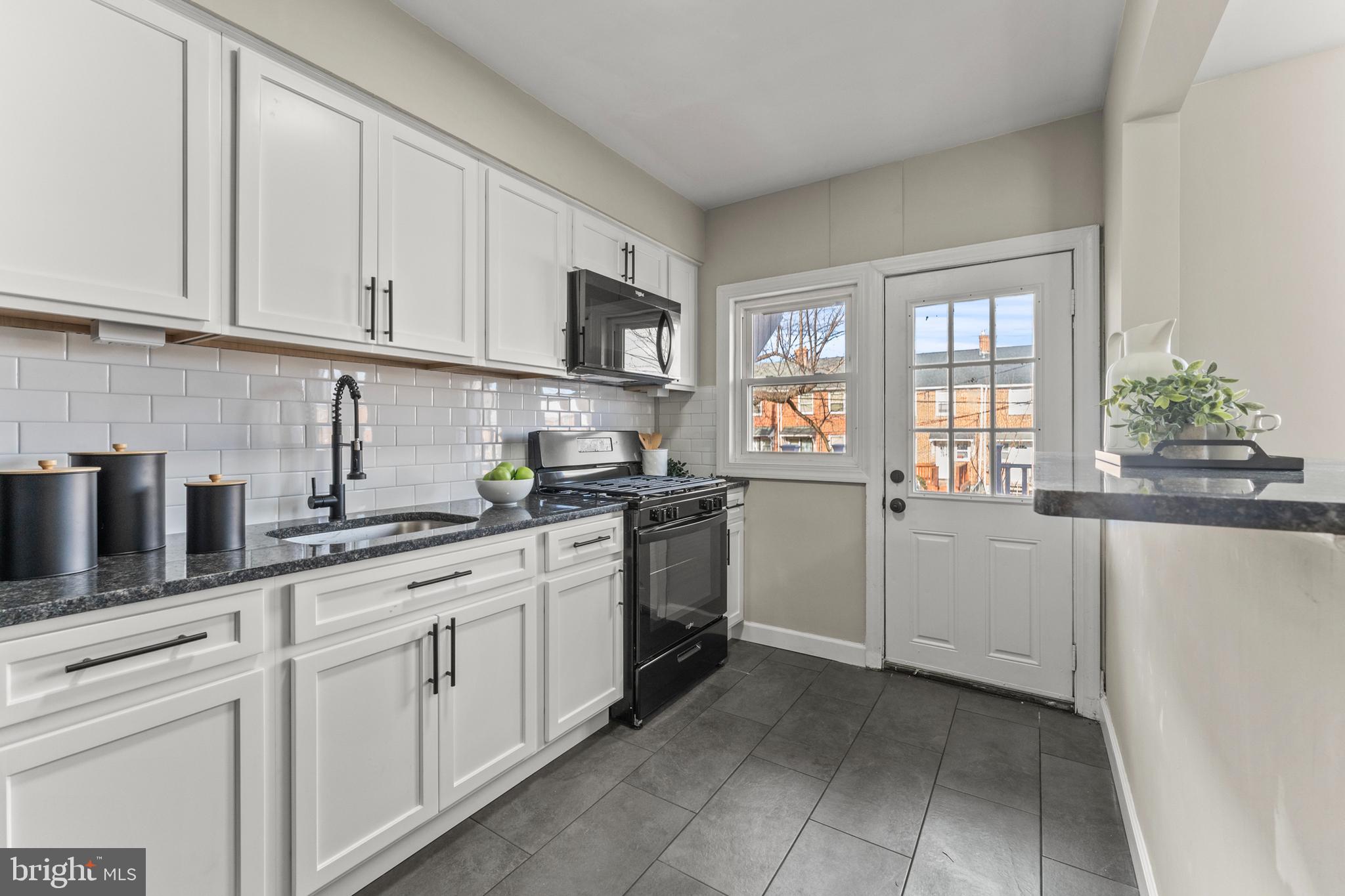 1324 Crofton Road Baltimore, MD 21239 - Photo 9 of 24 a kitchen with white cabinets and white appliances