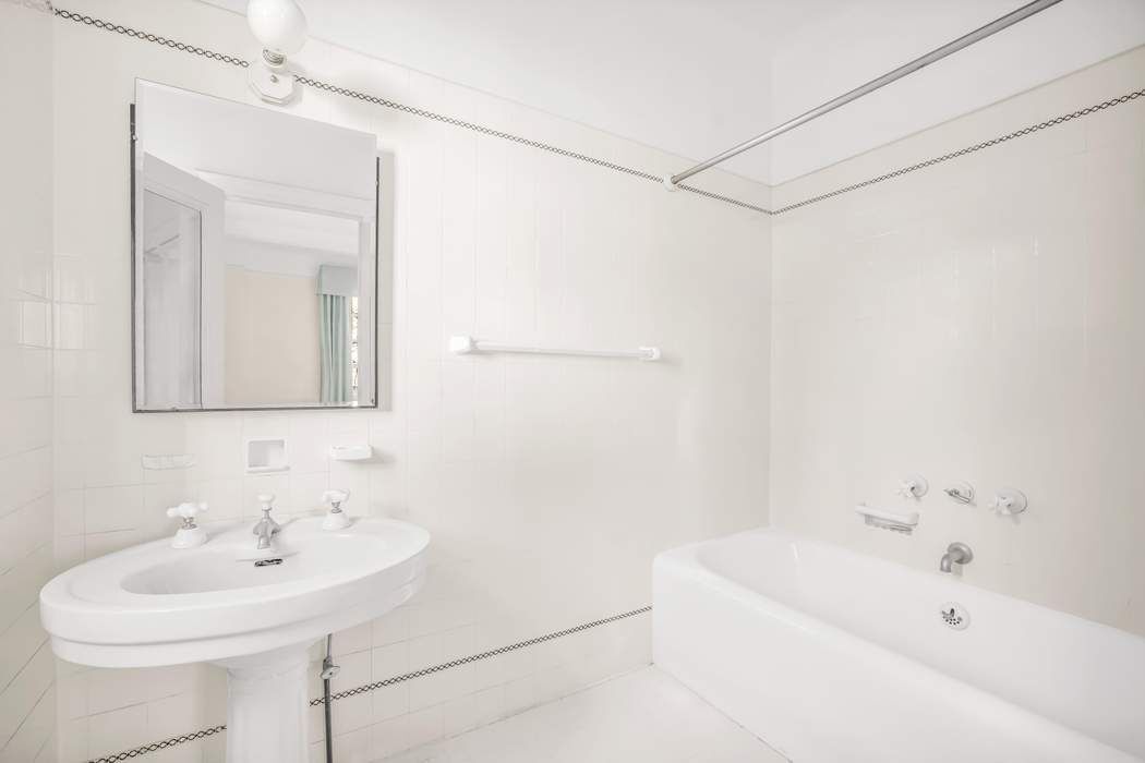 130 East 75th Street, Unit 3B Manhattan, NY 10021 - Photo 13 of 15 a bathroom with a sink a mirror and a bathtub