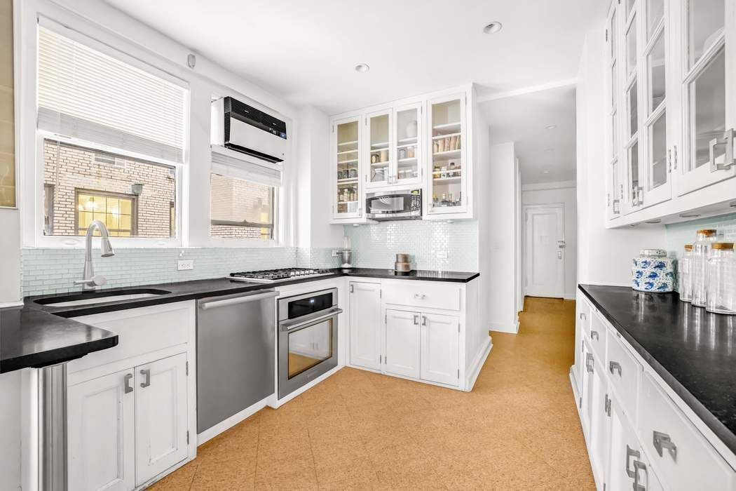 130 East 75th Street, Unit 3B Manhattan, NY 10021 - Photo 7 of 15 a kitchen with granite countertop a sink stove and cabinets