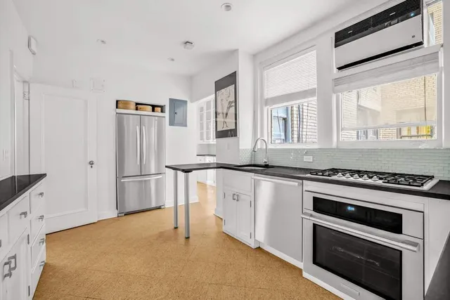 a kitchen with granite countertop a sink stove and cabinets