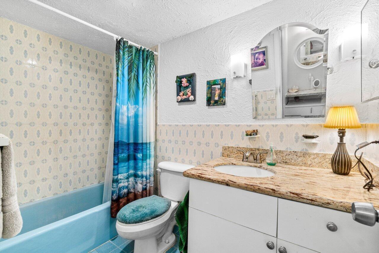 1124 Northwest 13th Street, Unit 204A Boca Raton, FL 33486 - Photo 14 of 30 a bathroom with a granite countertop sink mirror vanity and toilet