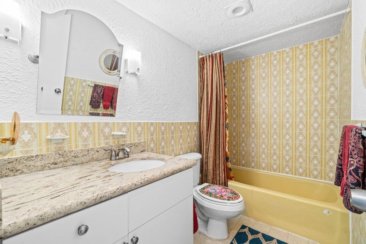 1124 Northwest 13th Street, Unit 204A Boca Raton, FL 33486 - Photo 17 of 30 a bathroom with a sink a toilet and a bathtub