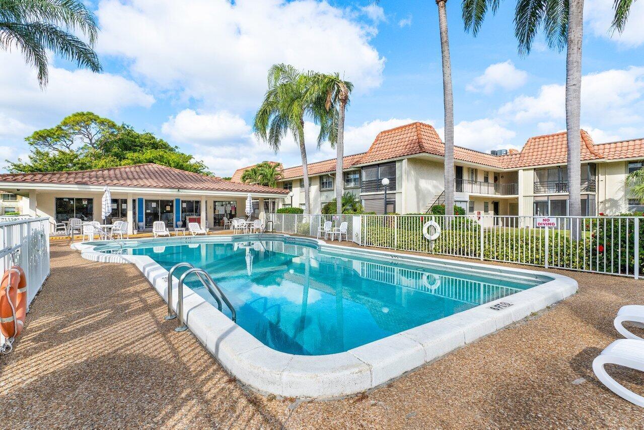 1124 Northwest 13th Street, Unit 204A Boca Raton, FL 33486 - Photo 27 of 30 a view of a house with swimming pool and a porch